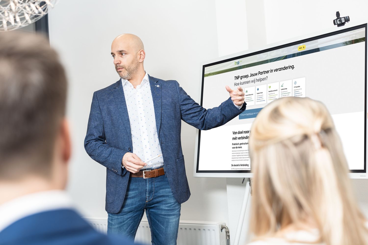 Een adviseur wijst op een scherm tijdens een workshop